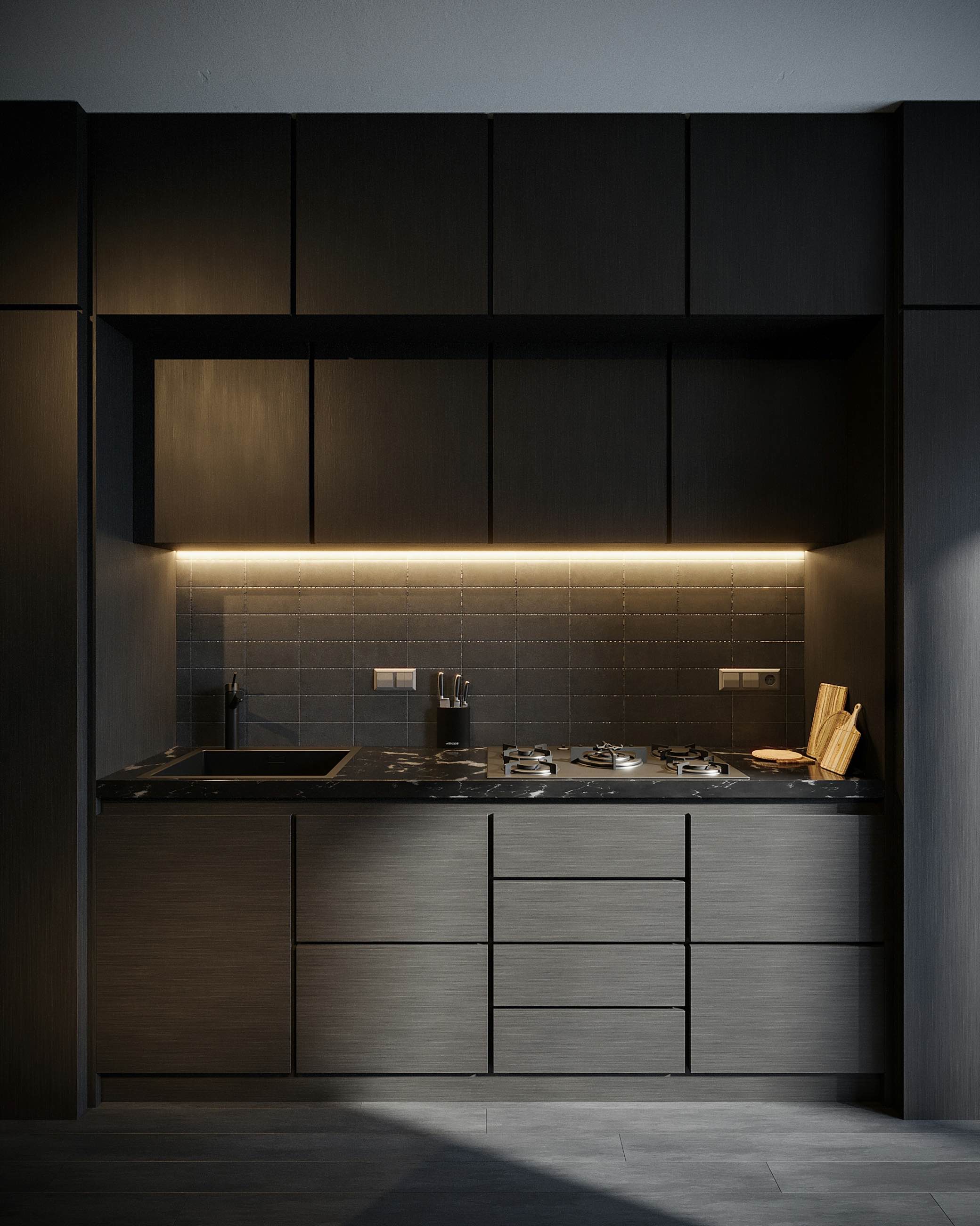 A dark kitchen wall with lit open shelving above the sink run